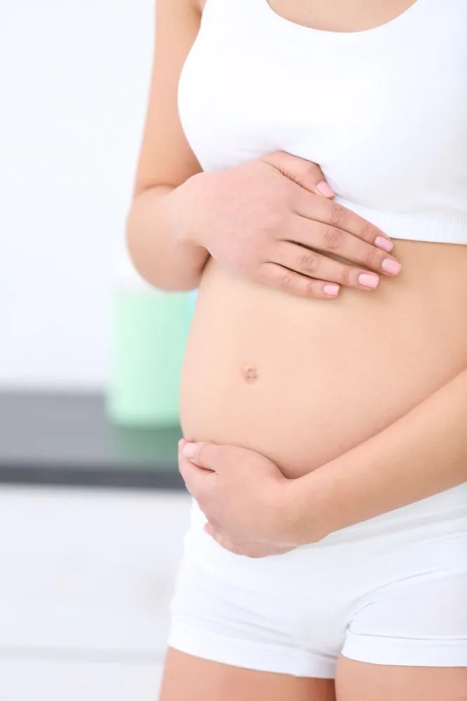 Femme enceinte posant les mains sur son ventre